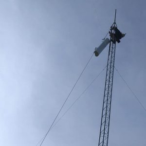 Leonard Smith pulls up the first radio and antenna to be installed on a new tower for wireless internet service.