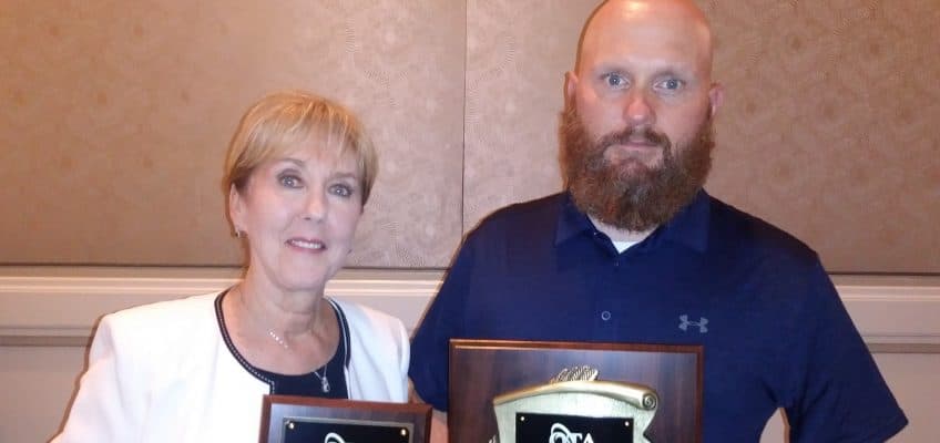 picture of Leslie Woodruff and James Powers accepting the OTA awards for Lyn Johnson and Gary Woodruff at the 2019 OTA Conference in St Louis, MO.